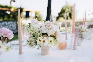 Çiçekler ve mumlarla düğün masası.