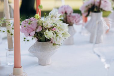 Çiçekler ve mumlarla düğün masası.