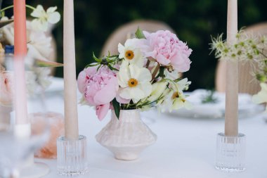 Çiçekler ve mumlarla düğün masası.