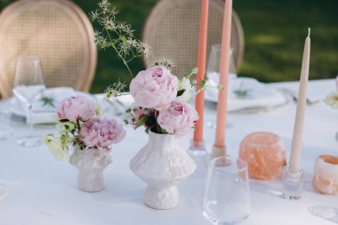 Çiçekler ve mumlarla düğün masası.