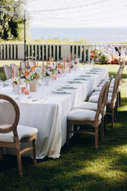 Bahçede sandalyeli bir düğün masası süsü.