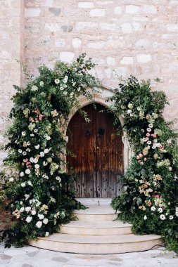 Çiçekli, ahşap kapılı güzel bir düğün kemeri.