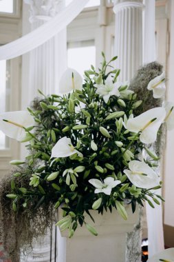 Düğün günü salonda bir buket beyaz çiçek.