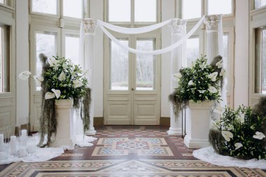 Düğün günü salonda bir buket beyaz çiçek.