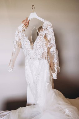 Yatak odasındaki askıda beyaz gelinlikli gelin..