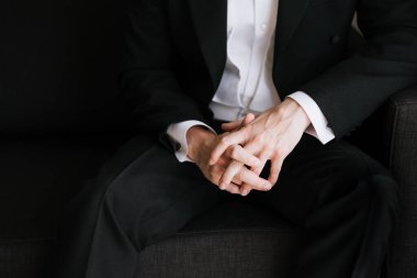 Düğünde damat, sandalyede siyah takım