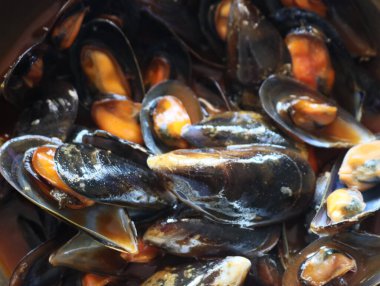 Sos içindeki lezzetli midyelerin tadı kabukluların kabuğunun tadını alır.