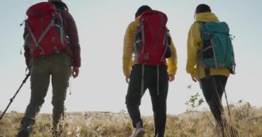 Üç Meksikalı yürüyüşçü kız şafakta dağın tepesinde olmayı kutluyor.