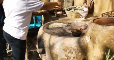 Geleneksel Meksika yemekleri olan Memela, aşçı kadınla pişiriliyor.