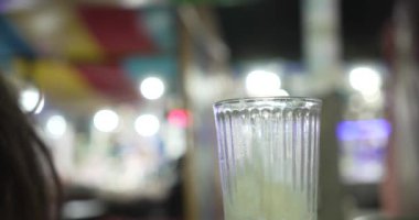 Bir kızın eli kaşıkla Meksika usulü şerbet içiyor.