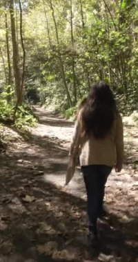 Ormanda yürüyen Meksikalı genç bir kızın dikey videosu.