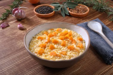 bowl of delicious risotto with pumpkin and herbs