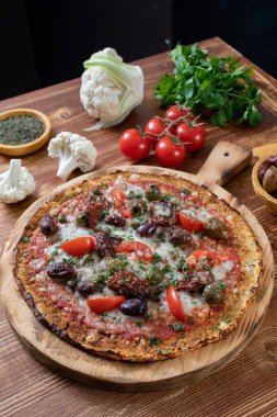 Tahtada salamlı, peynirli ve domatesli pizza.