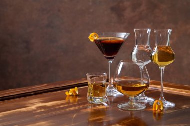 Bir bardak konyakla bir bardak viski ve ahşap bir masa.