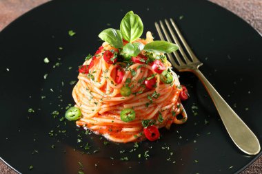 Domates soslu spagetti ve fesleğen yaprağı.