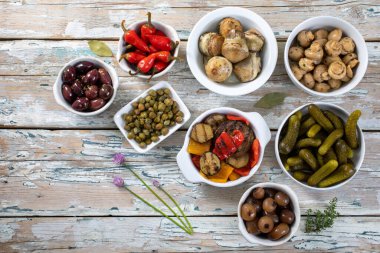 Beyaz ahşap arka planda farklı türde zeytin ve baharatlar. Kopyalama alanı olan üst görünüm. 