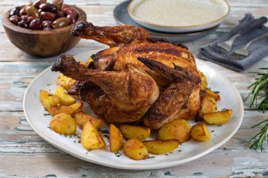 Tahta masada patates ve otlu fırında tavuk. 