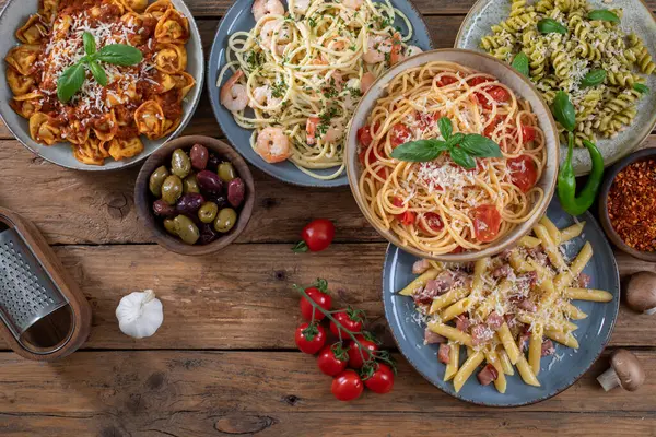 different italian pasta with different types of pasta on a wooden backgroun