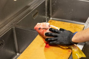 A Japanese chef processes fish to prepare sashimi.