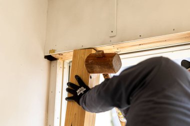 Japon marangoz elektrikli aletlerle çalışıyor, odun kesiyor ve inşaat alanında vida kullanıyor.