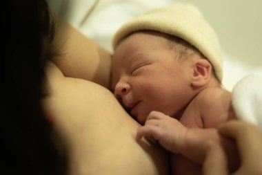 Doğumdan hemen sonra, Asya kökenli, beyaz, tapılası bebek derisi tutan bir kadının hayat tarzı. Yeni bir hayat ve ebeveynlik kavramında hastane yatağında mutlu bir şekilde yatması.