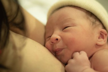 Doğumdan hemen sonra, Asya kökenli, beyaz, tapılası bebek derisi tutan bir kadının hayat tarzı. Yeni bir hayat ve ebeveynlik kavramında hastane yatağında mutlu bir şekilde yatması.