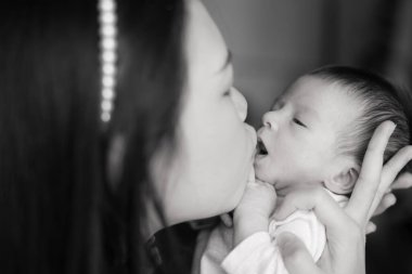 Genç ve mutlu Asyalı bir kadının anne-kız sevgi kavramını kollarında tutması sanatsal siyah-beyaz önemli bir yaşam tarzı.