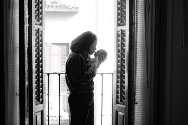 Genç ve mutlu Asyalı bir kadının anne-kız sevgi kavramını kollarında tutması sanatsal siyah-beyaz önemli bir yaşam tarzı.