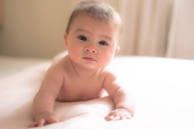 Sevimli ve mutlu 5 aylık bebek, neşe içinde yatağını keşfederken sonsuz mutluluğu keşfediyor. Doğal ışığın sıcacık parıltısıyla çevrili küçük gülümsemeler neşeyle