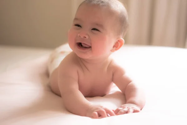 可爱而快乐的5个月大的女婴在玩耍探索自己的床的时候 高兴地发现无限的快乐 在温暖的自然光的照耀下 小小的笑容欢快地闪烁着 — 图库照片
