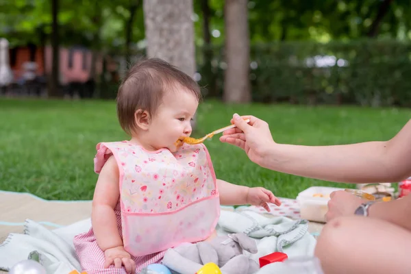 女性給餌彼女の美しい小さな娘 母の手と閉じるポートレートの愛らしいと幸せな赤ちゃんの女の子食べる赤ちゃん粥からスプーンで健康と栄養の概念 — ストック写真