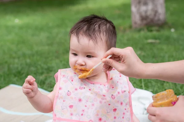 女性給餌彼女の美しい小さな娘 母の手と閉じるポートレートの愛らしいと幸せな赤ちゃんの女の子食べる赤ちゃん粥からスプーンで健康と栄養の概念 — ストック写真