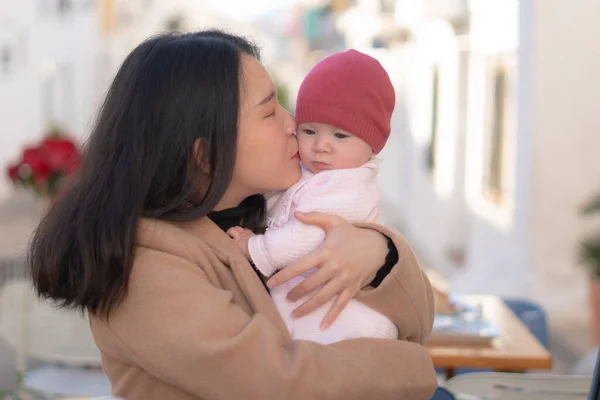 美丽的亚裔中国女人抱着可爱的女婴 一边在户外喝咖啡 一边和女儿谈情说爱 一边谈恋爱 — 图库照片