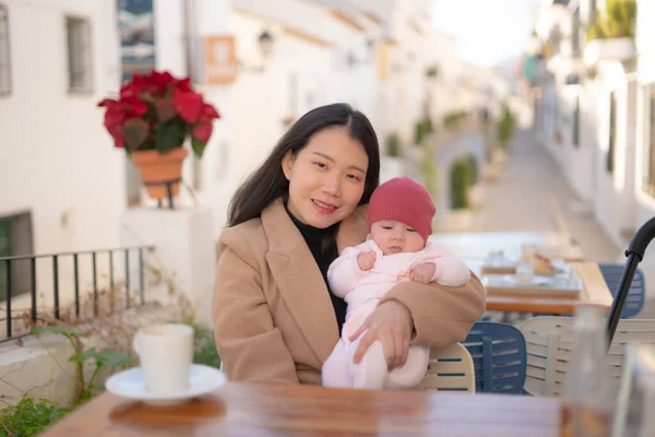 若いです幸せと美しいですアジアの女性持っています彼女の可愛いです赤ちゃん女の子を保持しながら コーヒー屋外で母娘愛と結合概念 — ストック写真