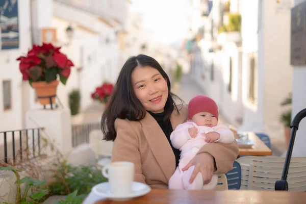 若いです幸せと美しいですアジアの中国人女性保持彼女の可愛いです赤ちゃん女の子を持っていますしながらコーヒー屋外で母娘愛と結合概念 — ストック写真