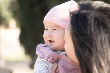 Genç bir Asyalı Çinli anne, küçük kızıyla sevgi dolu bir şekilde oynayıp, sonsuz bir sevgi bağı kurarken, saf bir sevinç. Annelik güzelliği ve çocukluk masumiyeti.