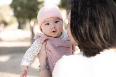 Genç bir Asyalı anne olarak saf neşe, küçük kızıyla sevgi dolu bir şekilde oynayarak, kalıcı bir sevgi bağı yaratıyor. Annelik güzelliği ve çocukluk masumiyeti.