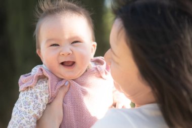 Genç bir Asyalı anne olarak saf neşe, küçük kızıyla sevgi dolu bir şekilde oynayarak, kalıcı bir sevgi bağı yaratıyor. Annelik güzelliği ve çocukluk masumiyeti.