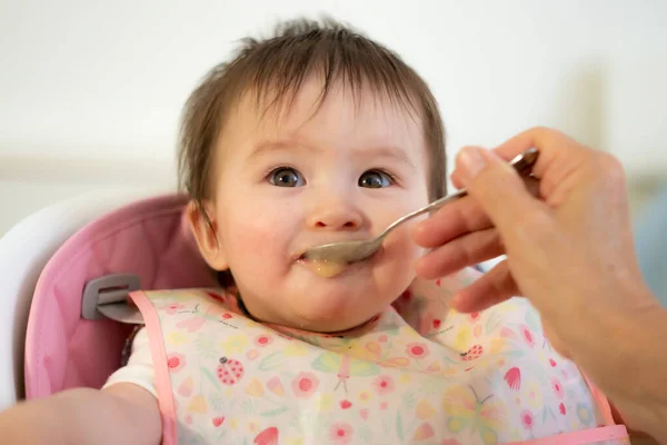 Mano Mujer Con Cuchara Puré Alimentación Niña Feliz Adorable Babero —  Fotos de Stock