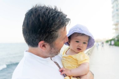 Baba ve küçük kızın açık hava yaşam tarzı portresi. Sevimli ve mutlu bebeğini ebeveyn konseptinde tatillerin tadını çıkarırken gören bir adam.