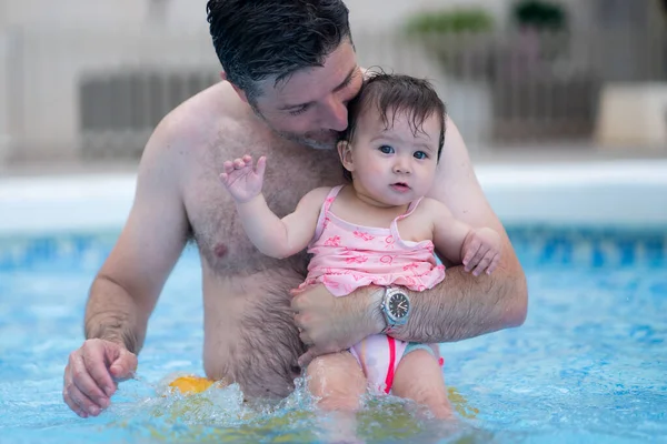 父亲和小女儿享受夏天的生活 男人抱着她可爱的女儿兴奋而快乐地一起在度假胜地游泳池里玩耍 带着养育孩子的观念 — 图库照片