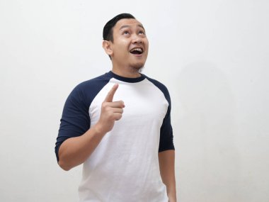 Genç Asyalı adam düşünmekten ve bakmaktan mutlu görünüyordu, iyi bir fikri vardı. Kopya alanı olan beyaz duvara yarı vücut portresi