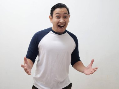 Mutlu, heyecanlı Asyalı adam gülümseyip gülüyor beyaz arka plana karşı, güzel ve şaşırtıcı bir zafer hareketi görmek için.