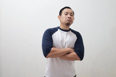 Portrait of Asian man looking at camera with sceptical arrogant coccky face, over white bckground