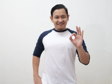 Asian man showing thumbs up with ok sign gesture, positive approval deal agreement concept
