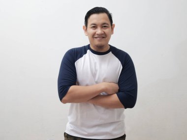 Portrait of happy young attractive cute Asian man smiling cheerfully, confident friendly gesture with arms crossed, against grey background