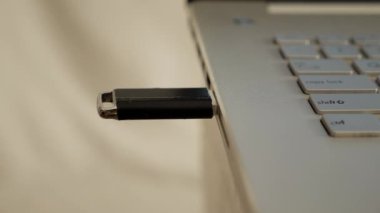 Person pluging out flashdisk from usb port in laptop personal computer, data transfer device concept, close up