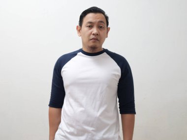 Portrait of Asian man looking at camera with sceptical face, over white bckground