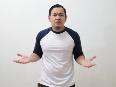 Omuz silkme hareketi yapan genç Asyalı adam, beyaz arka planda ne bileyim ya da reddediliyor.