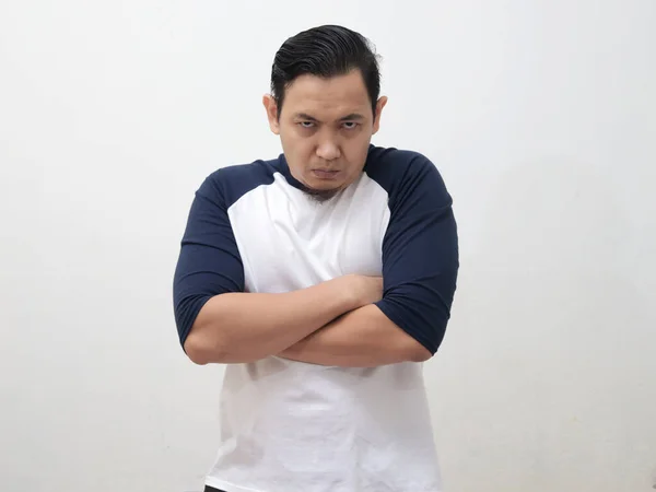 Asian man looked angry and shows critical attitude, crossed arms on chest with unhappy expression